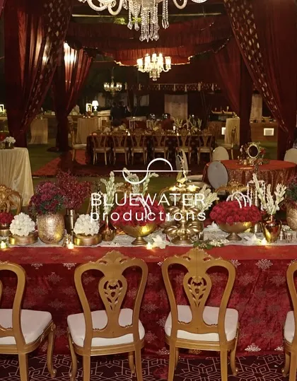 Another view of the royal dining setup, featuring brass vessels, red florals, and elegant seating under a draped canopy.