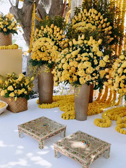 The traditional low seating for the Haldi ceremony in Dubai, surrounded by an abundance of yellow roses and marigolds.
