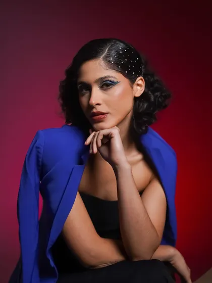 A close-up beauty shot from the blue and red series. This highlights the sparkling hair accessory and the bold blue eye makeup.