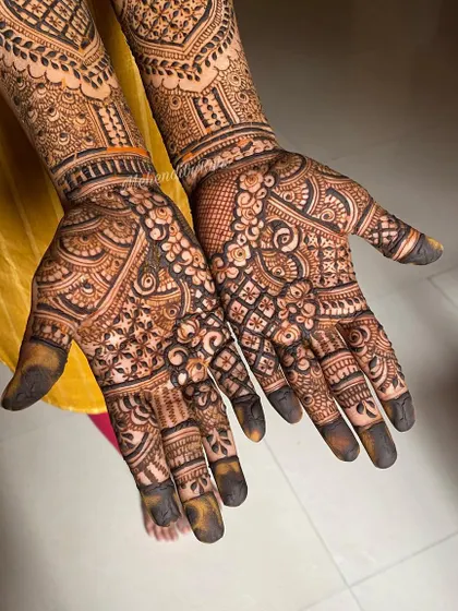 This design features heavy checkerboard patterns on the palms and intricate work on the fingers and wrists.