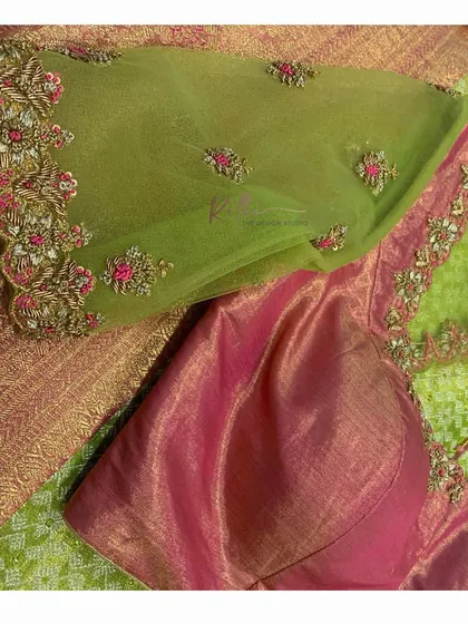 A detailed shot of the embroidery on the sheer green net sleeve of the blouse.