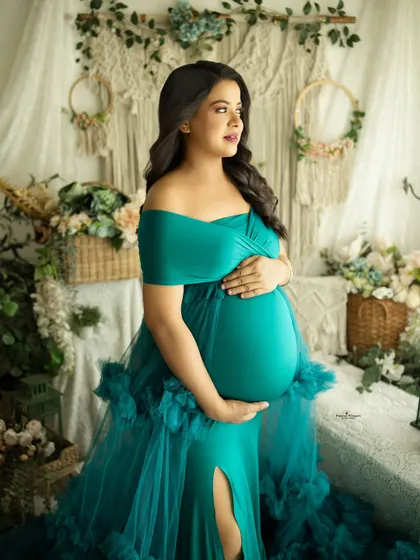 A confident and radiant solo portrait of a twin-mom-to-be. Her pose and the stunning teal gown beautifully celebrate her unique journey.