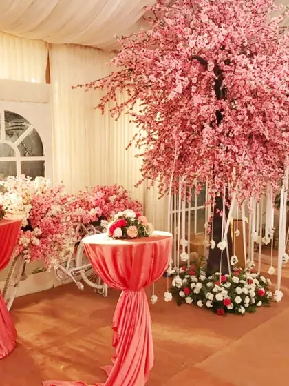A beautiful indoor floral decoration featuring a large artificial cherry blossom tree. This kind of statement piece can transform a venue and serve as a stunning photo background.