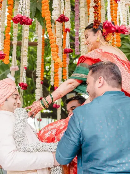 A fun and iconic moment from a Marathi wedding where the bride is lifted up for the varmala ceremony. The laughter and effort make this a lively and memorable shot.