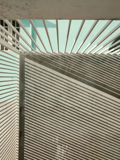 A close-up of the radiating pattern of shadows cast by the louvered gate and ceiling.