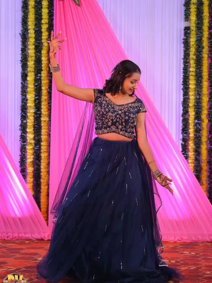 A client dancing gracefully at her event in the navy blue lehenga.