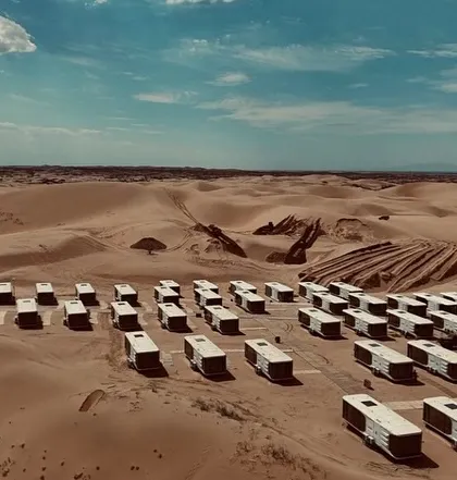 An aerial shot of our Space Capsule E8 units being deployed in a desert landscape. This showcases the scale and ambition of our modular hospitality projects.