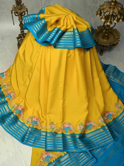 A vibrant yellow pure silk saree with a contrasting blue border. The border features charming elephant motifs, adding a touch of playful tradition to this beautiful piece.