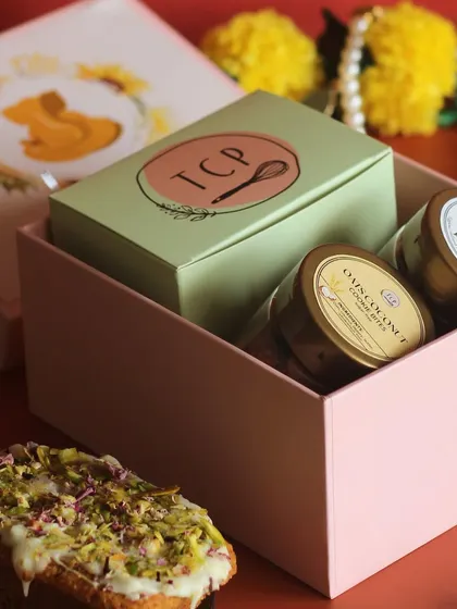 This box hamper for Ganesh Chaturthi is filled with love. It contains a vanilla pound loaf, sugar-free oat coconut cookie bites, and orange chocolate cookie bites.