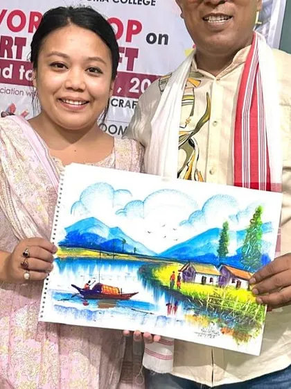 The first day of my Art and Craft workshop at Doomdooma College, presenting a completed landscape painting to a participant.