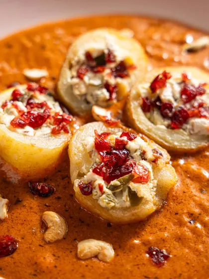 Stuffed potatoes in a rich, creamy gravy from Gallops. The close-up shot reveals the texture of the filling and the thickness of the sauce.