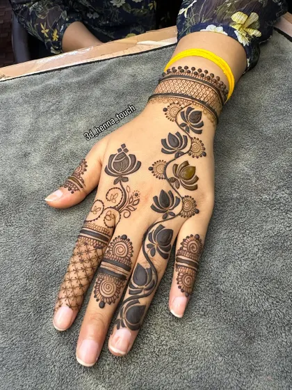 A bold and modern design featuring a trail of lotus flowers. The dark, filled-in lotuses create a striking contrast against the skin.
