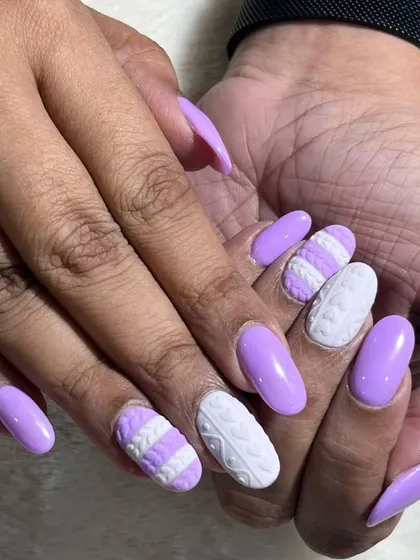 A full view of the lavender sweater nails. The combination of solid lavender and textured white accent nails creates a unique and stylish winter look.