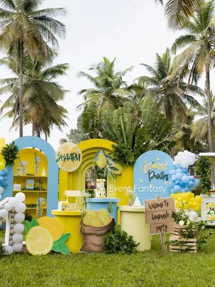 A bright and sunny lemonade-themed party, perfect for an outdoor celebration. This cheerful setup features a fresh color palette of yellow and blue, a lemonade stand prop, custom signage, and oversized lemon cutouts, making for a zesty and unique birthday experience.