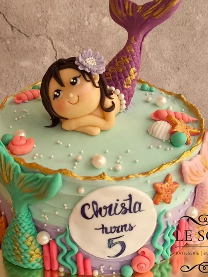 This magical mermaid cake was for Christa's 5th birthday. The 1 kg Vanilla Caramel cake is decorated with a beautiful hand-sculpted mermaid figurine, colorful tails, and seashell details.