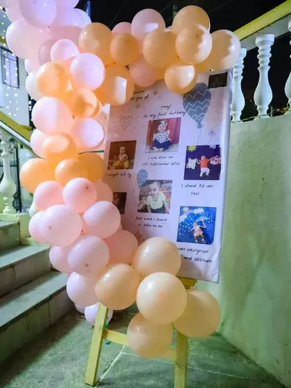 A milestone board is a wonderful way to share your baby's journey. We created this photo display on an easel, framed with matching balloons, to showcase memories from the first year.