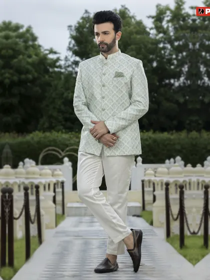 This pastel green Jodhpuri suit offers a unique color choice for festive wear. The subtle geometric print on the jacket, paired with off-white trousers, makes for a stylish and modern ethnic outfit.