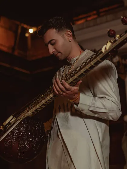 A close-up shot with my sitar in Nepal, highlighting the intricate details of the instrument and my traditional attire.