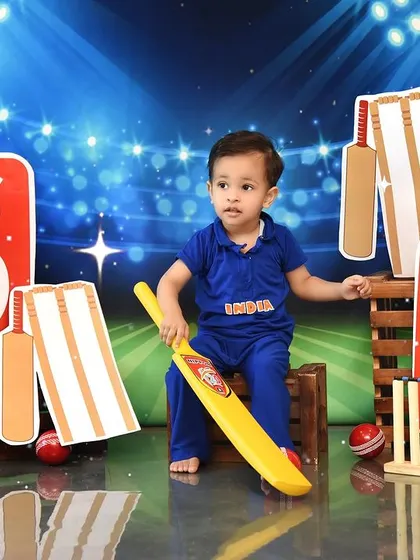 A future cricket champion surrounded by all the gear. This setup is perfect for a birthday or just for fun, capturing their passion for the sport.