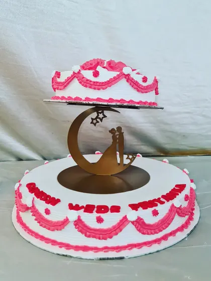 A classic floating-tier wedding cake. This design features traditional white and pink piping and a romantic couple silhouette topper, symbolizing the start of a new journey.
