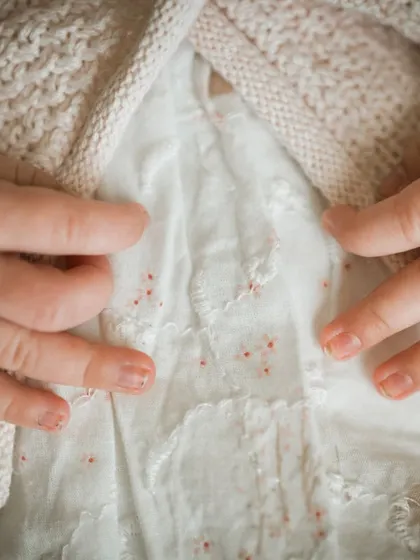 A macro shot focusing on the tiny, delicate hands of a newborn. These detail shots are a beautiful way to remember just how small they once were.