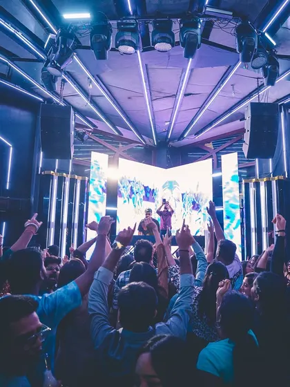 A wide-angle shot showing the impressive lighting rig and the crowd reaching towards the stage. It's a futuristic, spaceship-like vibe.