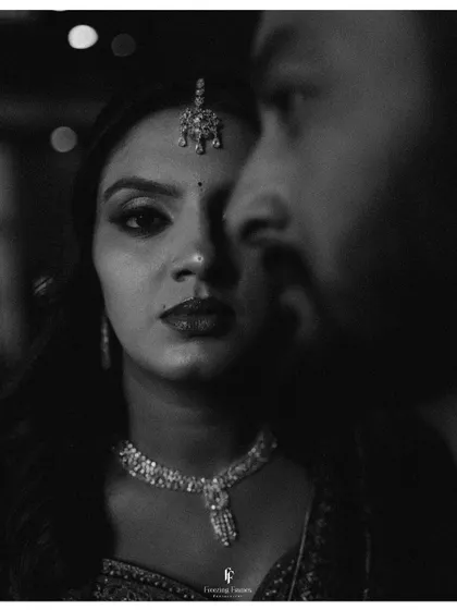 A dramatic black and white close-up of the couple, focusing on the bride's intense gaze.