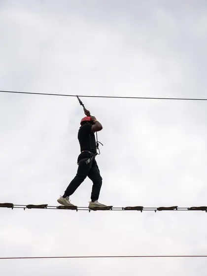 Our staff bonds as a team during an adventure outing at Suggee Resort, tackling a rope bridge challenge.