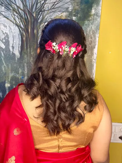 The back view of this half-up style, showing the line of fresh pink flowers that adds a festive touch.