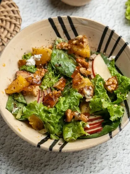 A fresh salad served in one of my hand-painted bowls. The black stripes add a modern, graphic touch to the earthy stoneware, creating a beautiful contrast with the vibrant food.