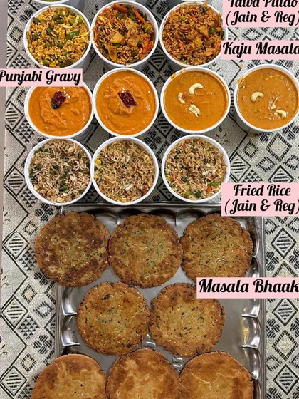 A spread of delicious gravies and rice. This order included Tawa Pulao, Kaju Masala, and Punjabi Gravy, available in both regular and Jain versions.