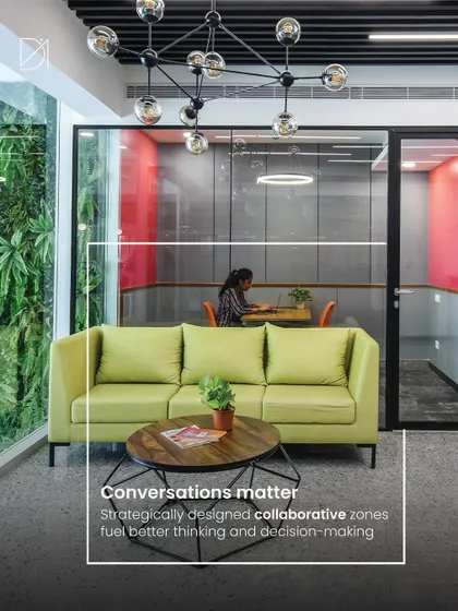 This collaborative zone is strategically placed next to a vertical garden, bringing the calming effects of nature into meeting spaces. The comfortable sofa and modern chandelier create a sophisticated yet relaxed setting for conversations.