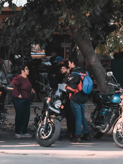 A candid street scene from the Royal Enfield meetup, showing a group of riders gathered and talking. It provides a real-life glimpse into the community's interactions.