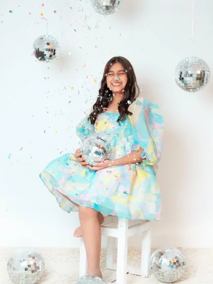 Celebrating a 10th birthday with a fun and vibrant photoshoot. The confetti and disco balls create a perfect party atmosphere.
