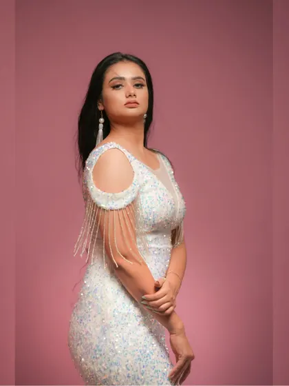 A close-up portrait in the white sequin dress, showcasing a subtle and elegant makeup look.