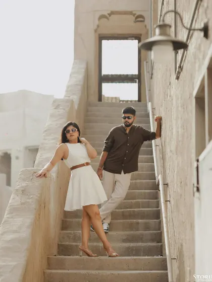 A stylishly posed shot on a staircase in Dubai, showcasing a mix of modern fashion and rustic architecture. This is a great example of a contemporary pre-wedding portrait.