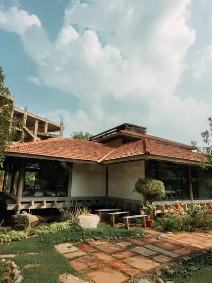 An exterior view of the center, showing its unique architecture and integration with the surrounding nature. It is a true sanctuary in the heart of Delhi.