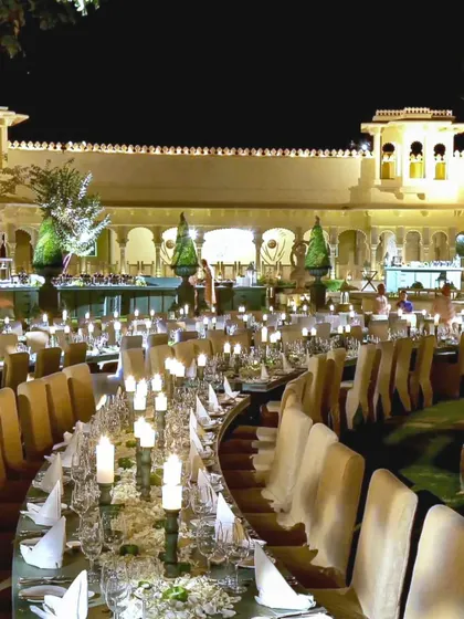 The welcome dinner at Udaivilas was a feast for the senses. We designed this elegant, curved dining setup with hundreds of candles to create a warm, intimate glow against the palace's stunning architecture.
