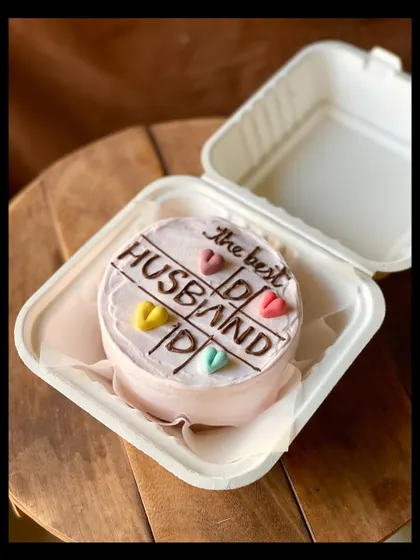 A sweet cake for "the best HUSBAND," designed with a tic-tac-toe theme and colorful hearts. It's a playful way to show your love and appreciation.