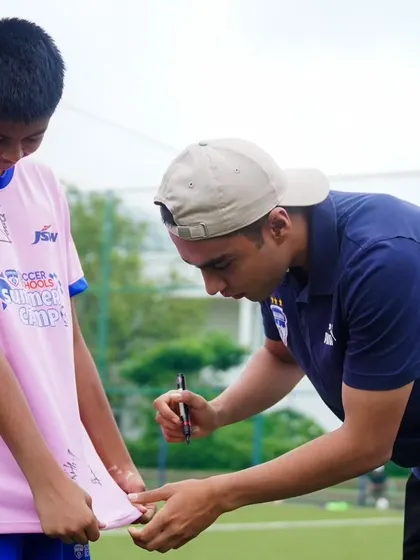 A BFC first-team player signs a jersey for a young fan from the Loyola Football Team, visiting from Pune for a High-Performance Camp.