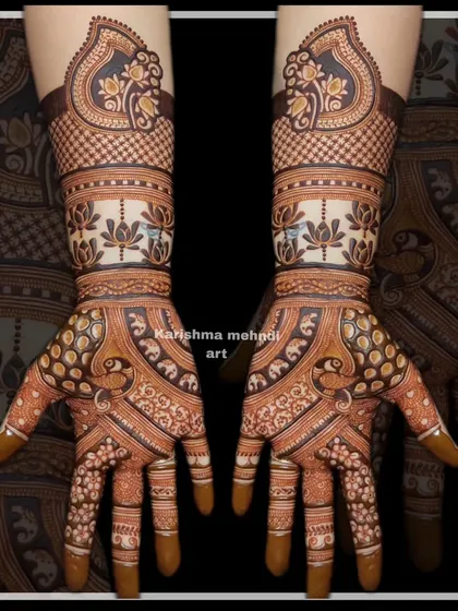This guest mehendi features a band of lotus flowers and elephants on the palms, topped with a traditional paisley motif on the wrist.
