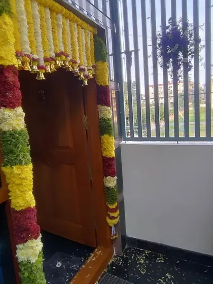 A close-up of the flower garlands on a main door. The craftsmanship ensures a neat and beautiful finish for your home's entrance.