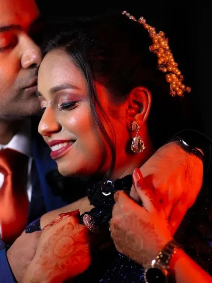 An intimate embrace under dramatic red lighting. This photo from their reception is full of passion and romance, showcasing a different side of their celebration.