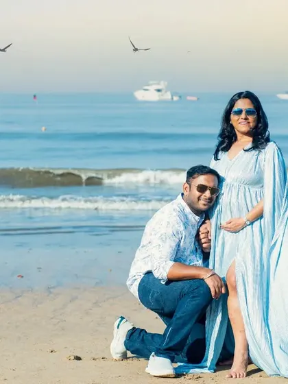 A beautiful day at the beach for a maternity shoot. The father-to-be listens to the baby bump, creating a sweet and memorable photo against the backdrop of the blue sea and sky.