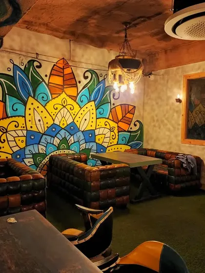 A full view of one of the large, leaf-inspired mandala murals that serves as a backdrop for the lounge seating.