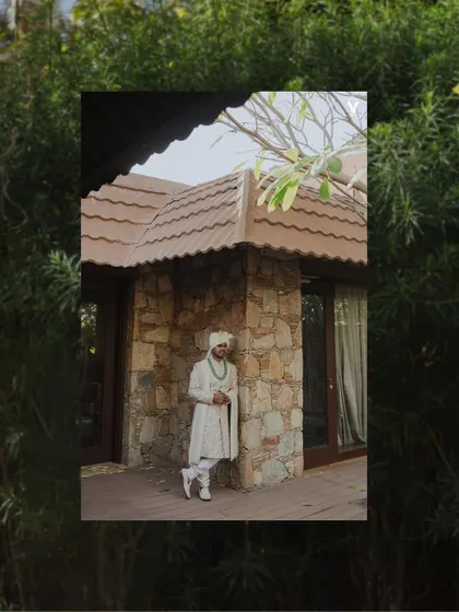 A creative portrait of the groom framed by lush green foliage. The composition uses natural elements to create a sense of being enveloped by the beautiful Udaipur surroundings.