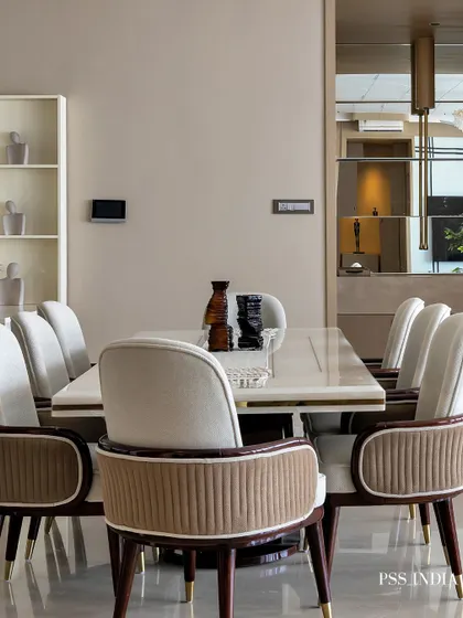 This dining room is all about creating an inviting atmosphere. The elegant white and brown chairs surround a marble-topped table, while a statement floral mosaic wall adds a touch of artistic flair.