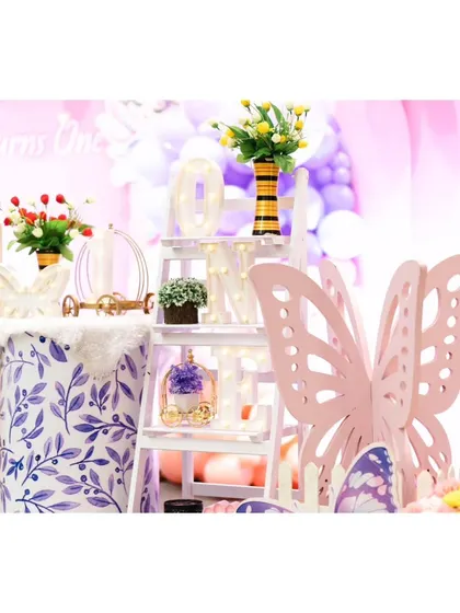 A close-up of the detailed props used in our butterfly-themed parties, including a large pink butterfly cutout and a decorative ladder shelf.