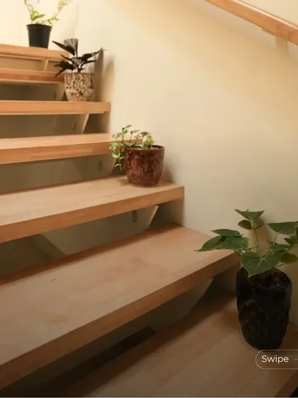 Duplicate of 193. Small potted plants are placed on the steps of the staircase, adding a touch of green and life to the simple, elegant design.