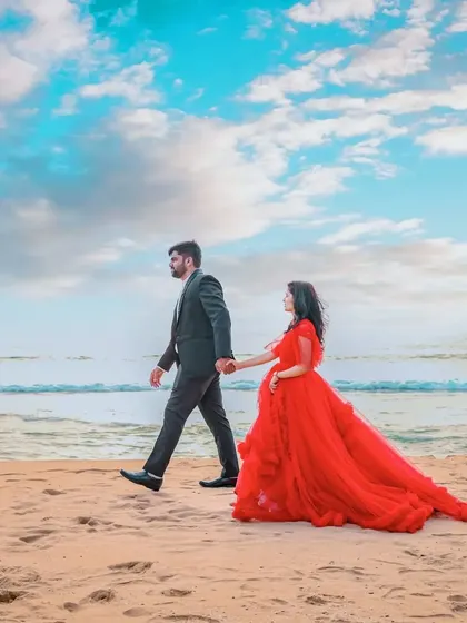 Walking along the shore hand-in-hand. This is a classic pre-wedding shot, made even more beautiful by the flowing red ruffle gown.